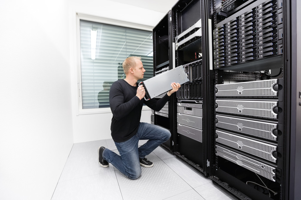 мужчина в дата центре работает с VDS / VPS серверами, которые сдают в аренду